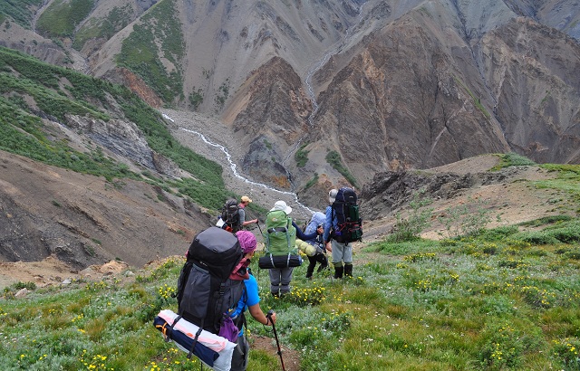Scouts descend into a steep river carved valley in the Yukon Territory